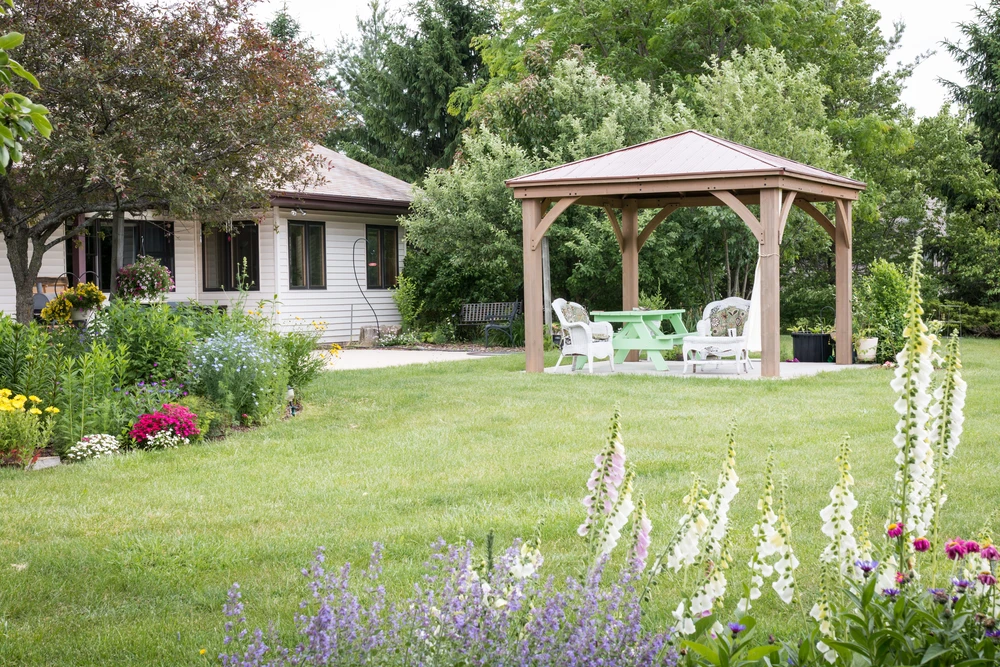 Jardin privé entouré d'un jardin fleuri et d'une pergola pour les journées chaudes d'été
